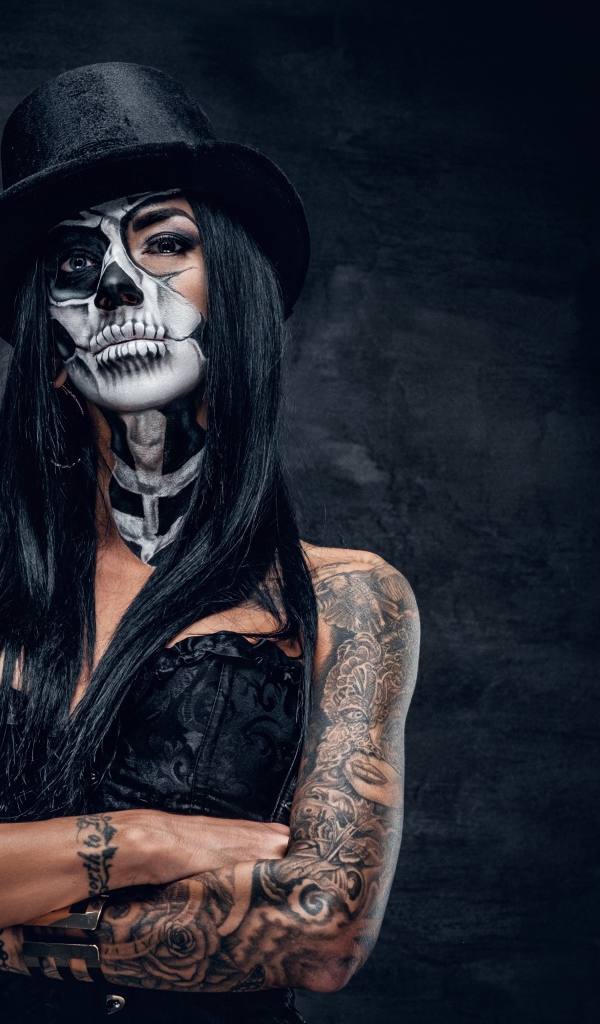 Девушка с гримом на лице с татуировками на руках