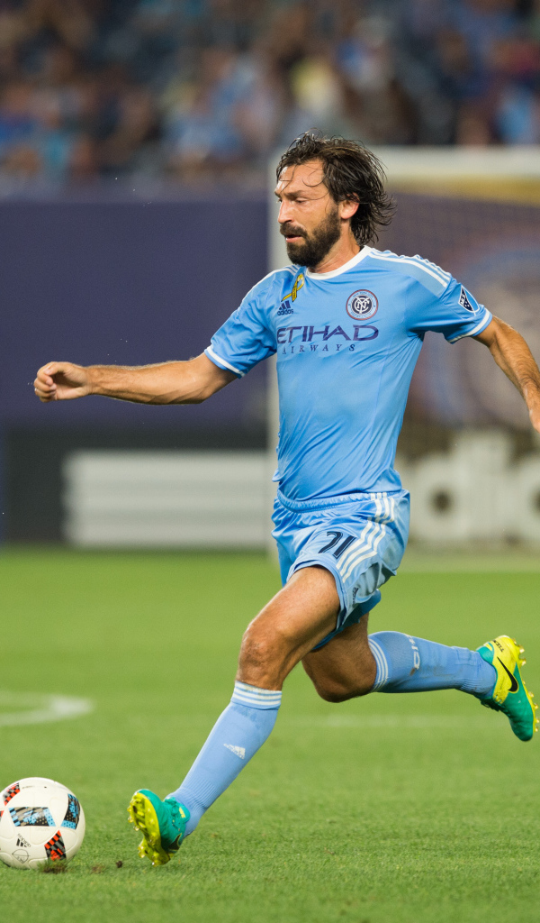 Итальянский футболист Андреа Пирло отбивает мяч на футбольном поле