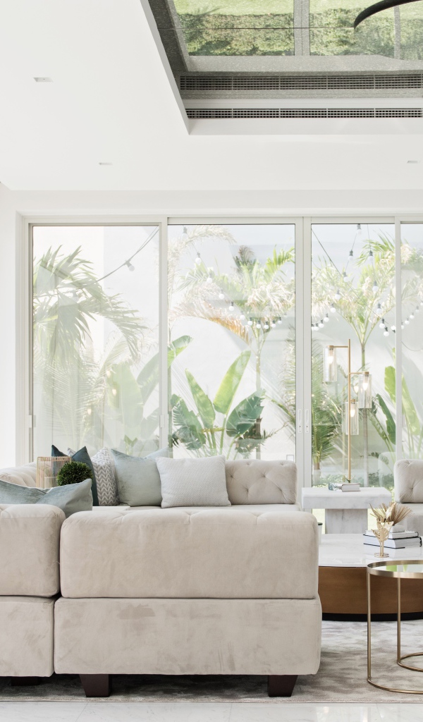 Большая гостиная комната с диваном и большими окнами