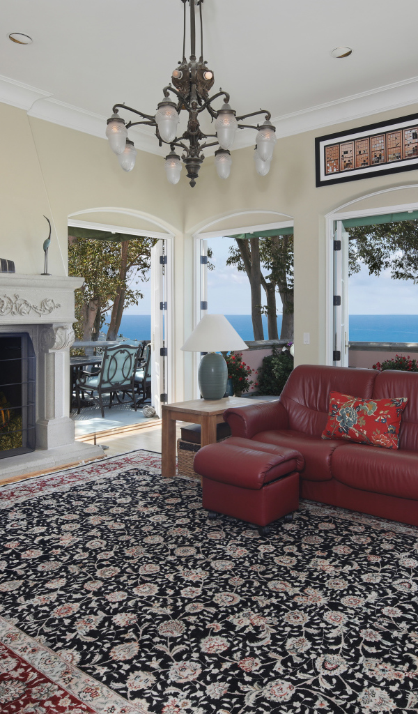 Гостиная с кожаным диваном, большими окнами и камином 