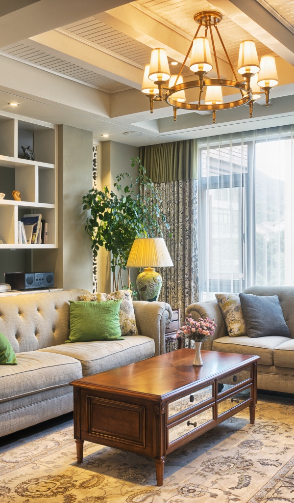 Много мягкой мебели в гостиной комнате с люстрой