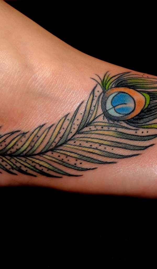 Татуировка перо павлина на ноге на черном фоне