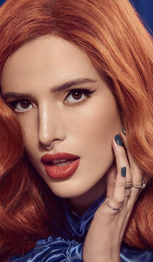 Рыжеволосая актриса Белла Торн на синем фоне