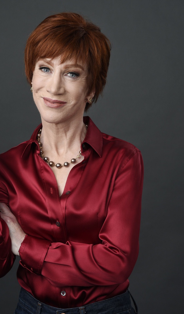 Рыжеволосая актриса Кэти Гриффин в красной рубашке на сером фоне