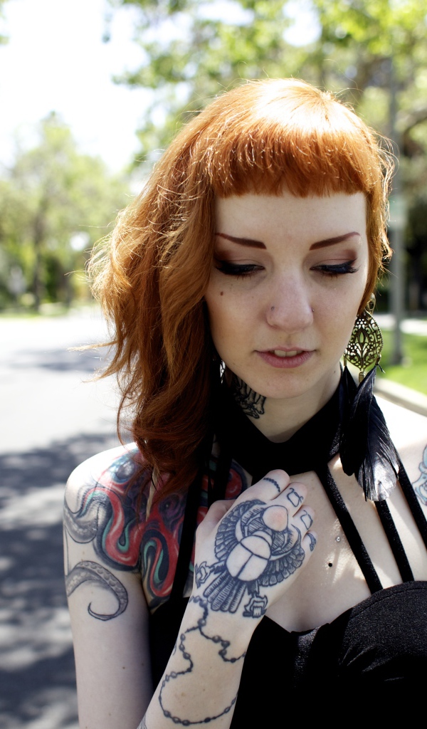 Рыжеволосая девушка неформалка с татуировками на теле