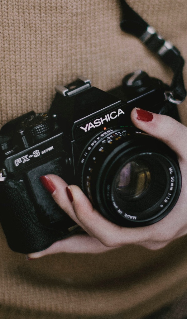 Зеркальная камера Yashica FX-3 в руках у девушки