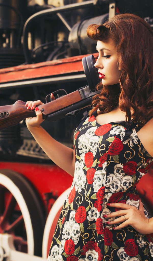 Девушка ретро с автоматом в руке  у тепловоза 