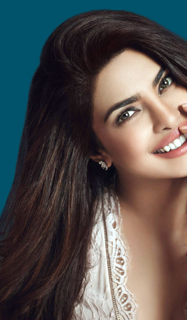 Улыбающаяся девушка, индийская актриса Приянка Чопра на синем фоне