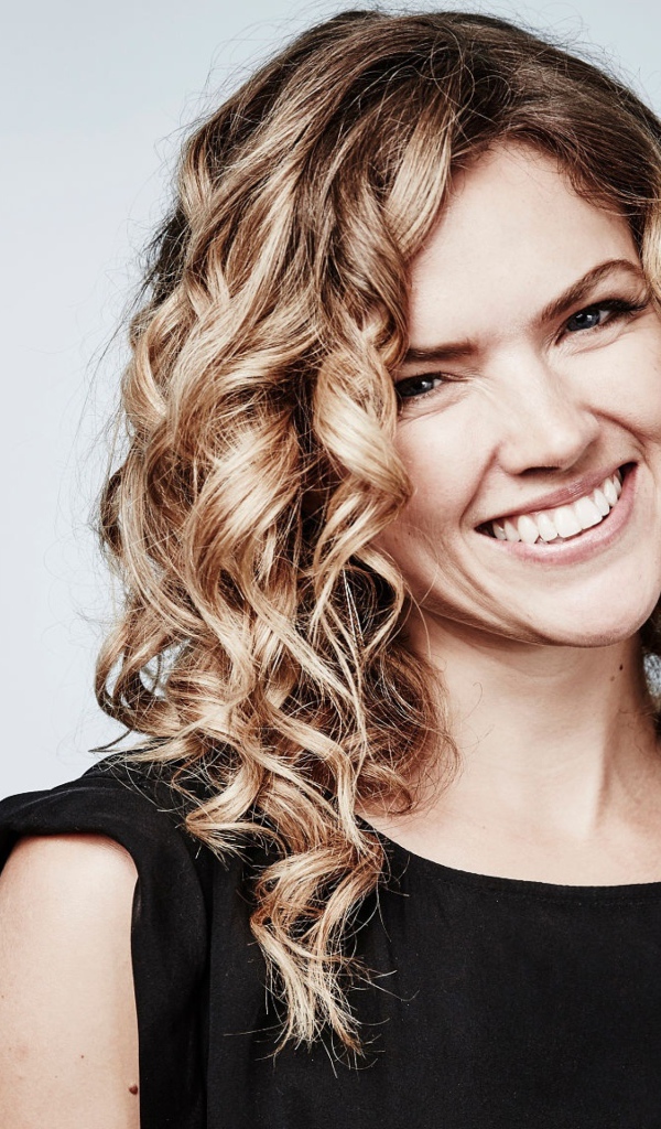 Улыбающаяся блондинка, актриса Эрин Ричардс на сером фоне