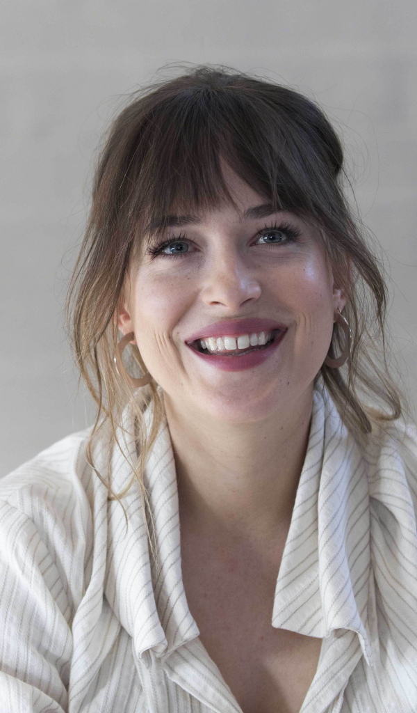 Улыбающаяся девушка актриса Дакота Джонсон в рубашке