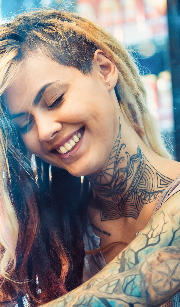 Улыбающаяся девушка с татуировками на теле