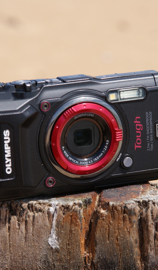 Стильный фотоаппарат Olympus Tough TG-5 стоит на пне