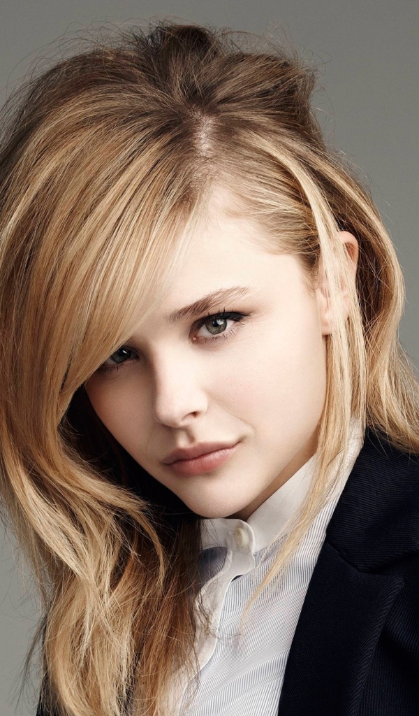 Стильная девушка, актриса Хлоя Грейс Морец в костюме на сером фоне