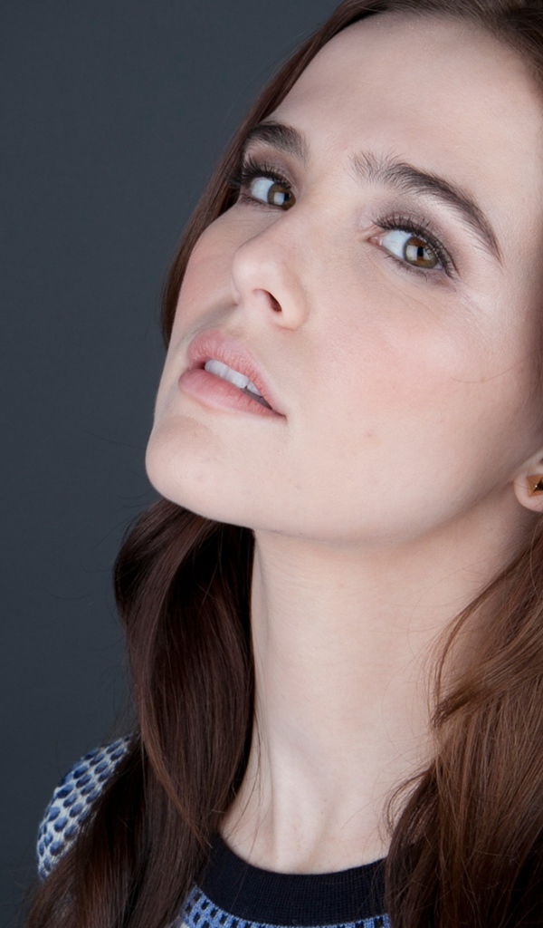 Нежная кареглазая шатенка, актриса Зои Дойч на сером фоне