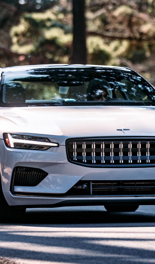 Белый автомобиль Polestar 1 2021 года едет по дороге