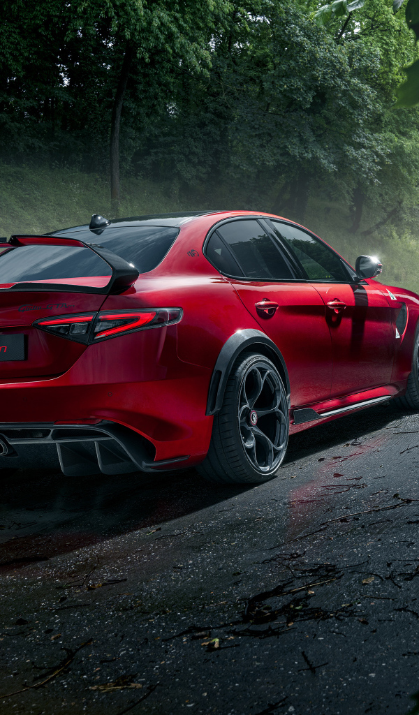 Красный автомобиль Alfa Romeo Giulia GTAm, 2021 года на дороге в лесу