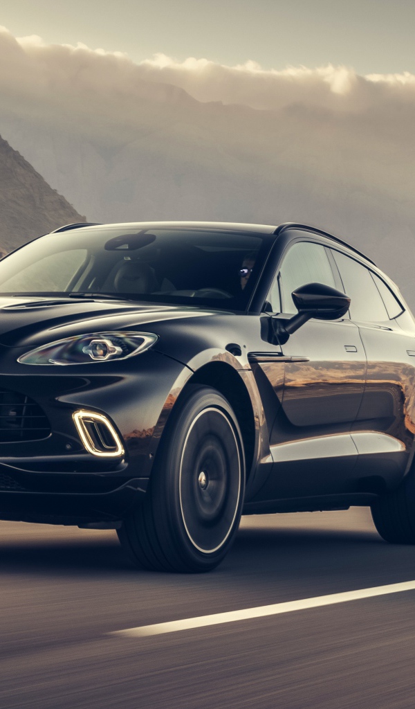 Черный автомобиль Aston Martin DBX 2020 года на трассе