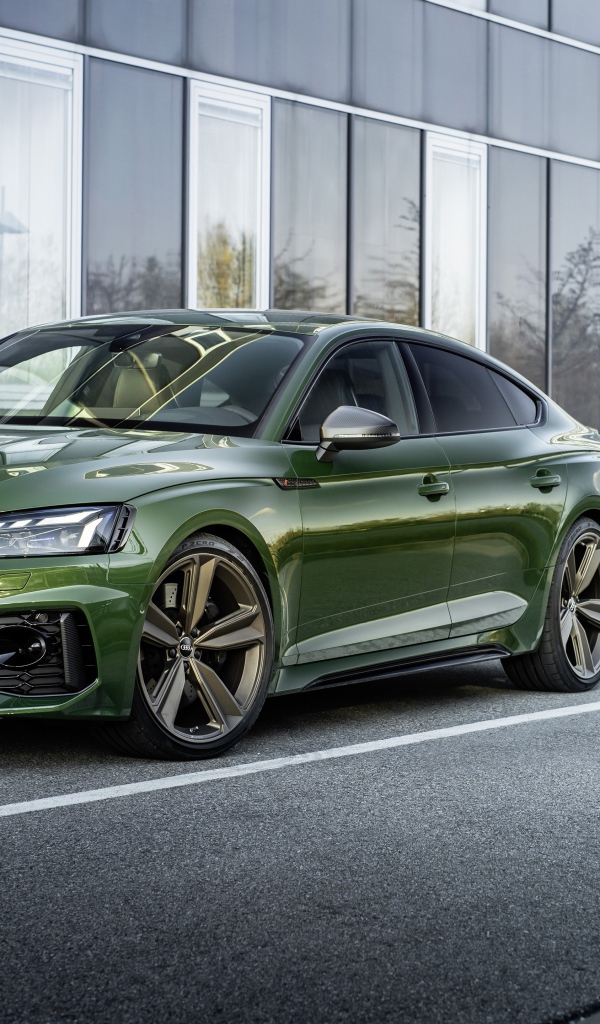 Зеленый автомобиль Audi RS 5 Sportback 2020 года у здания 