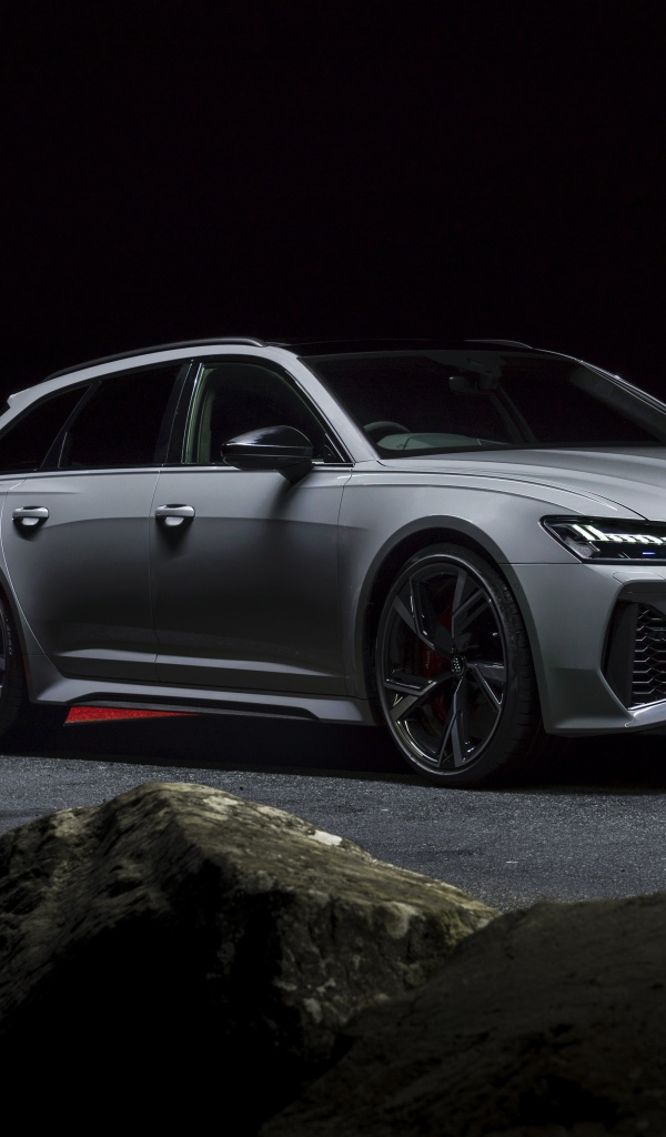 Серебристый автомобиль Audi RS 6 Avant 2020 года на дороге ночью 