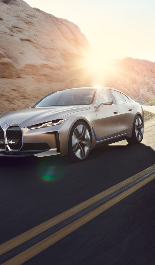Автомобиль BMW Concept I4 2020 года у гор в лучах солнца