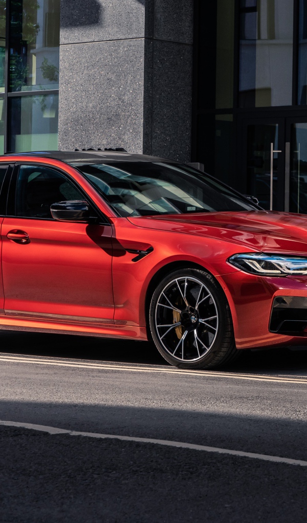 Красный автомобиль BMW M5 Competition 2020 года у дома