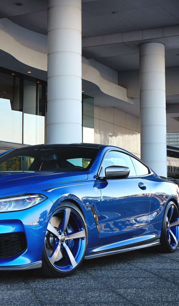 Синий автомобиль BMW M850i XDrive Coupe 2020 года у здания 