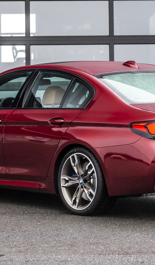 Красный автомобиль BMW M550i XDrive, 2021 года вид сзади
