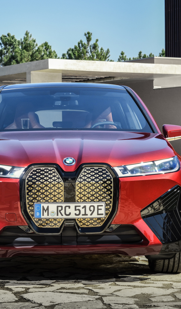 Красный автомобиль BMW IX 2021 года у дома