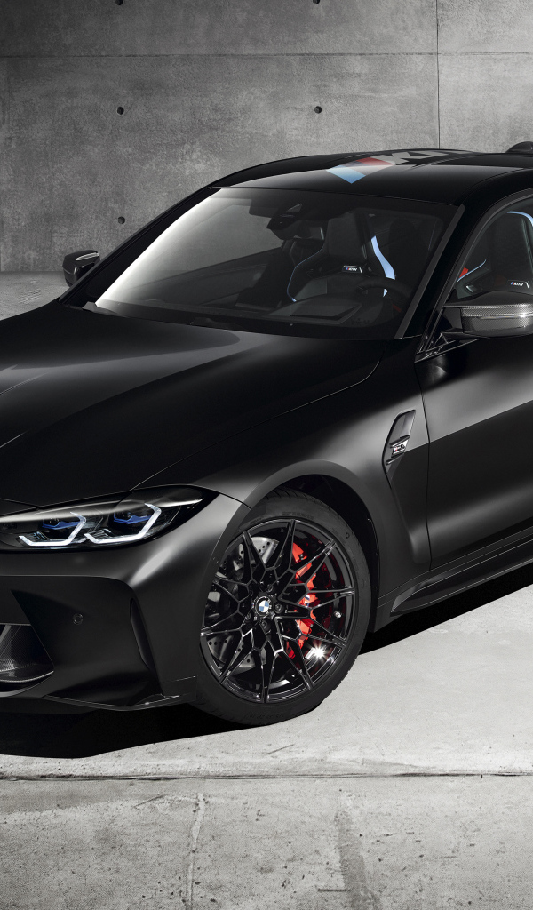 Черный автомобиль BMW M4 Competition X Kith 2020 года на фоне серой стены