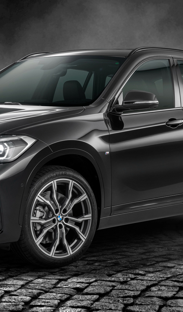 Черный автомобиль BMW X1 SDrive20i M Sport 25 Anos 2020 года в свете софитов