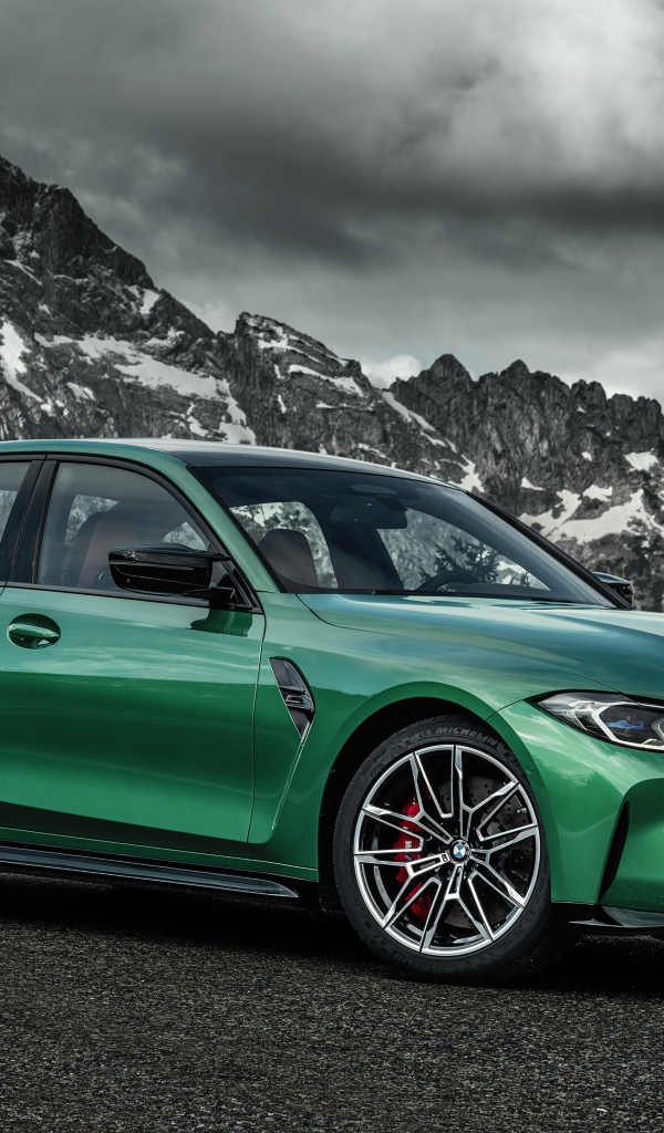 Зеленый автомобиль BMW M3 Competition 2020 года на фоне горы