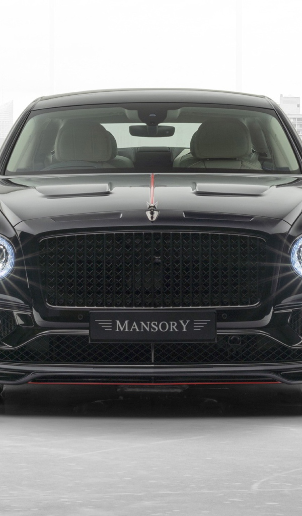 Черный автомобиль Mansory Bentley Flying Spur 2020 года с включенными фарами 