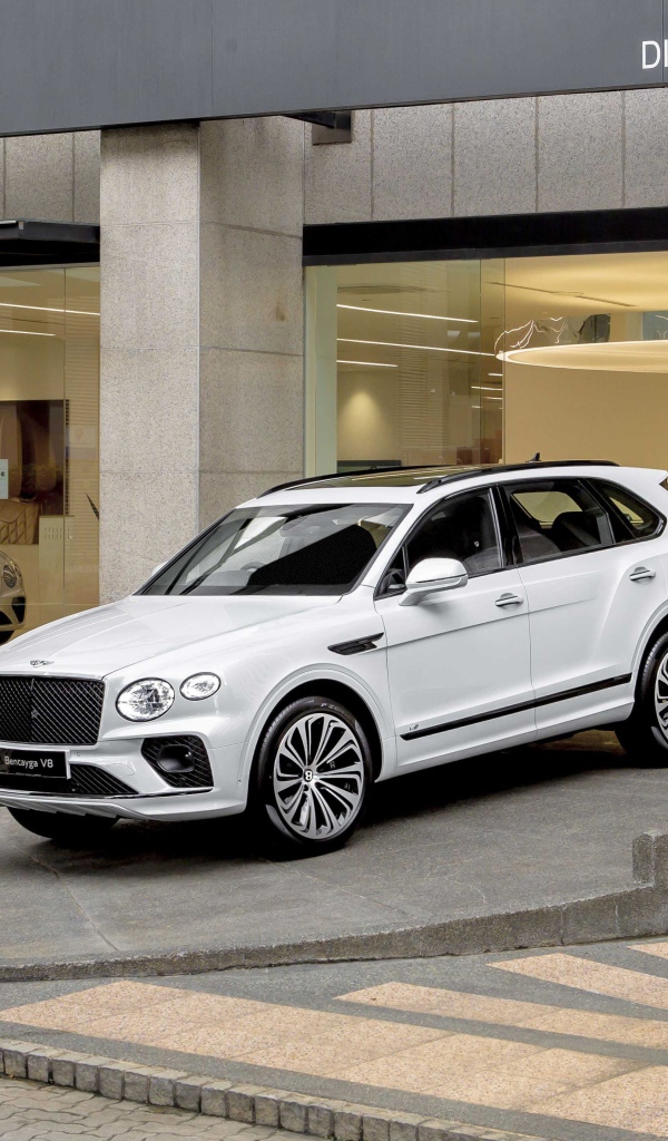 Белый автомобиль Bentley Bentayga V8 First Edition 2020 года выезжает из автосалона 
