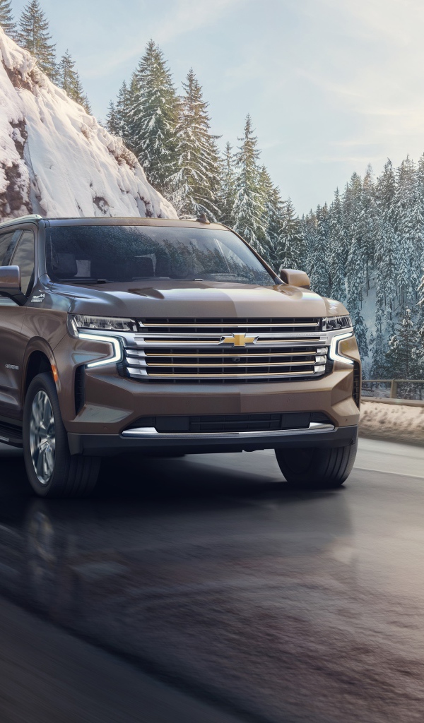 Внедорожник Chevrolet Suburban на фоне заснеженного леса, 2021 года