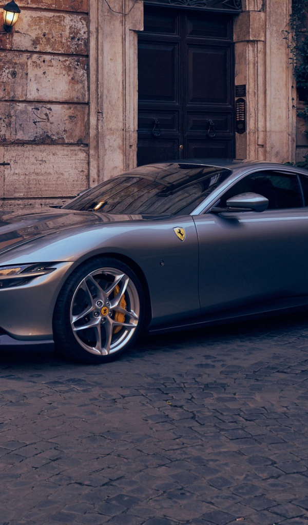 Серебристый автомобиль Ferrari Roma 2020 года у кафе