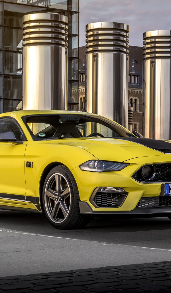 Быстрый желтый автомобиль Ford Mustang Mach 1 2021 года у здания 