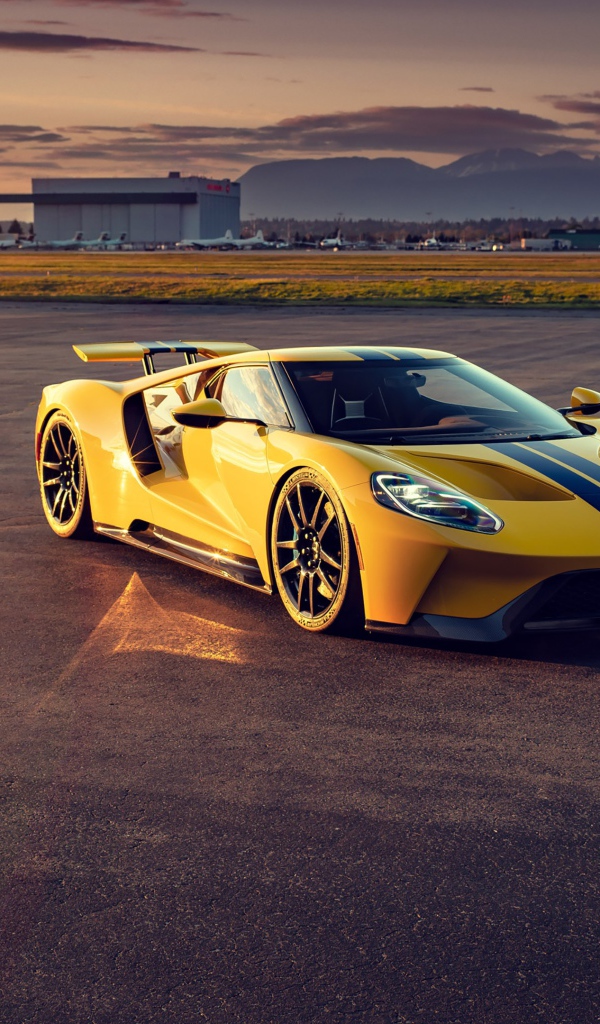 Желтый гоночный автомобиль Ford GT на взлетной полосе 