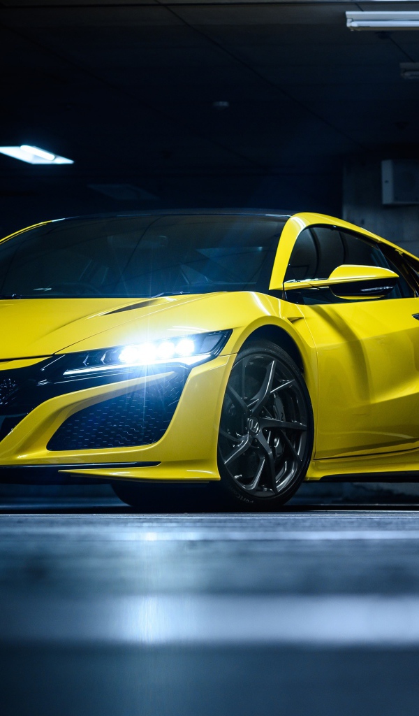 Желтый автомобиль Honda NSX с включенными фарами 
