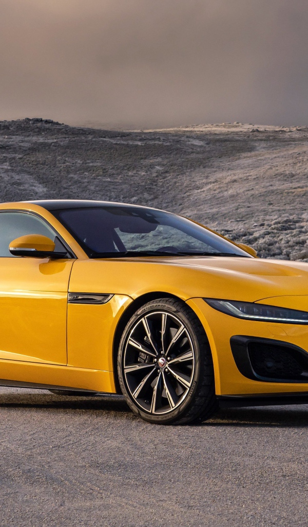 Желтый автомобиль Jaguar F-Type R Coupe 2020 года на фоне холмов