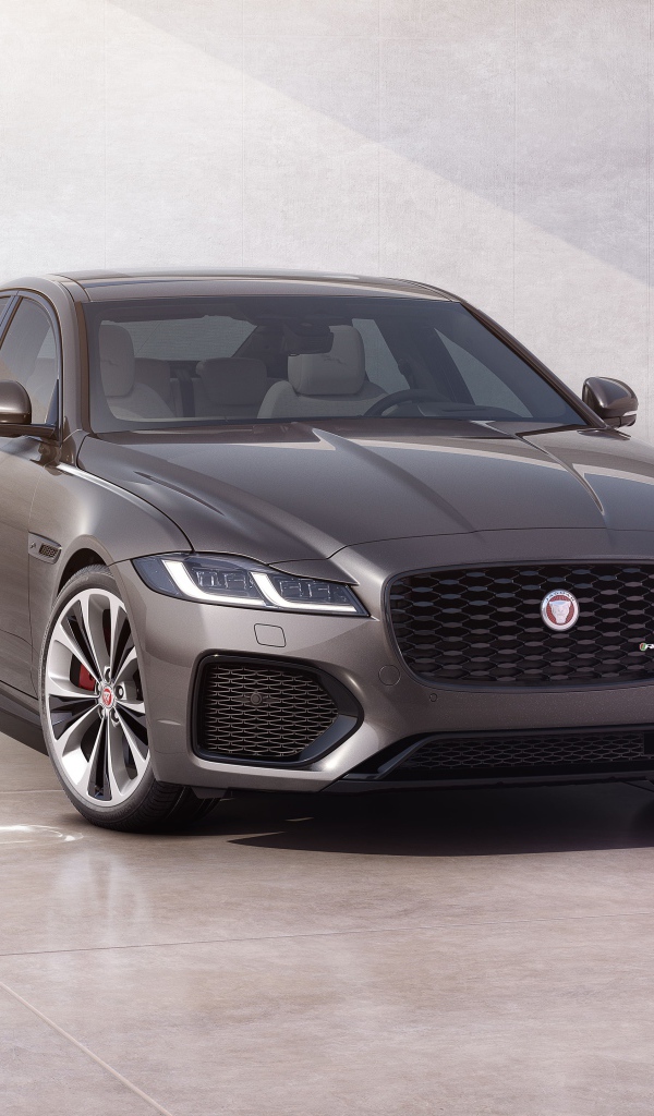 Автомобиль Jaguar XF P300 AWD R-Dynamic 2020 года у серой стены 