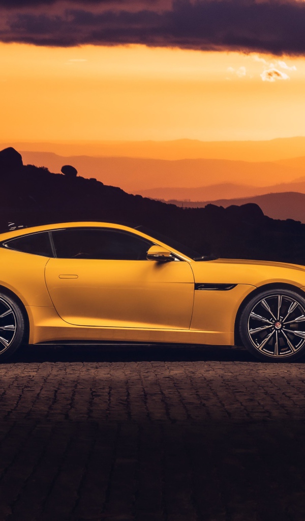 Желтый автомобиль jaguar f type 2020 года на закате 