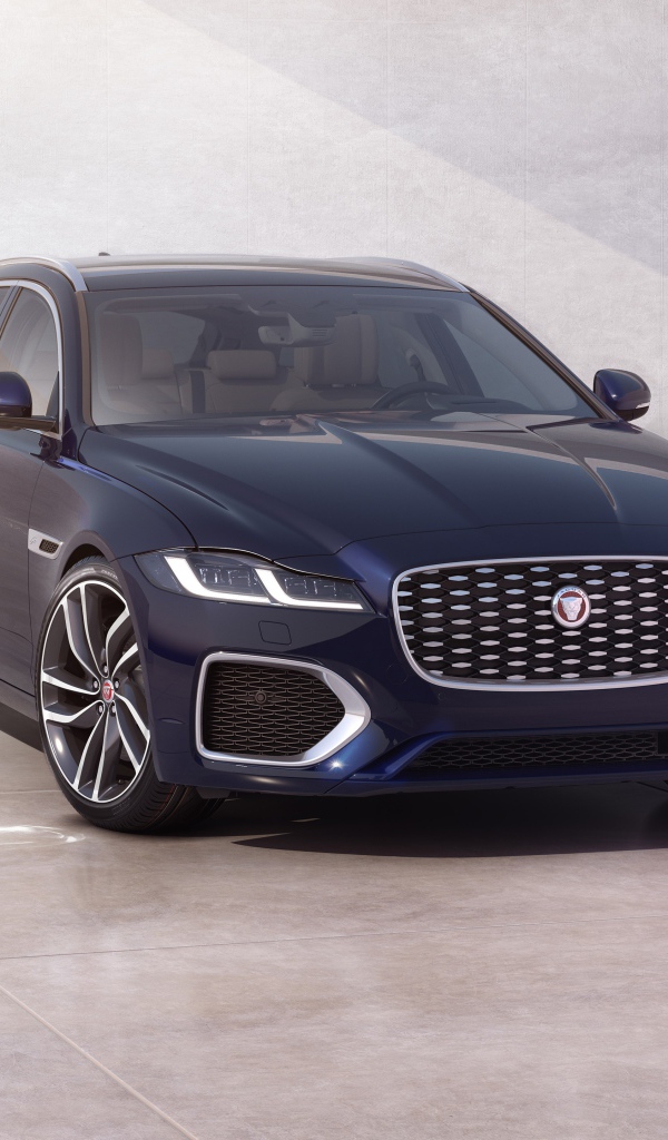 Синий автомобиль Jaguar XF Sportbrake 2020 года у стены 