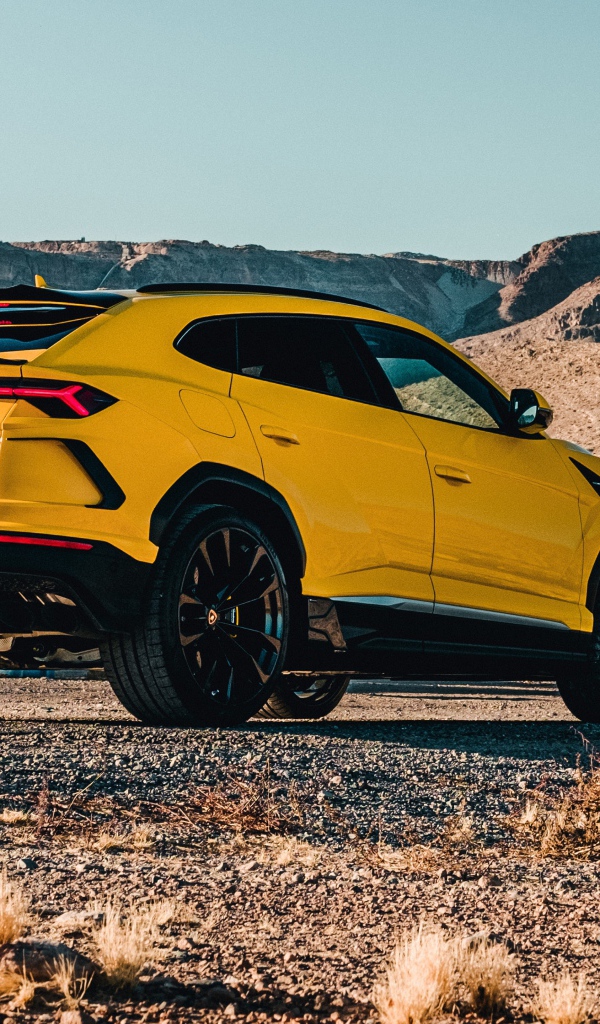 Желтый автомобиль Lamborghini Urus 2019 года в горах 