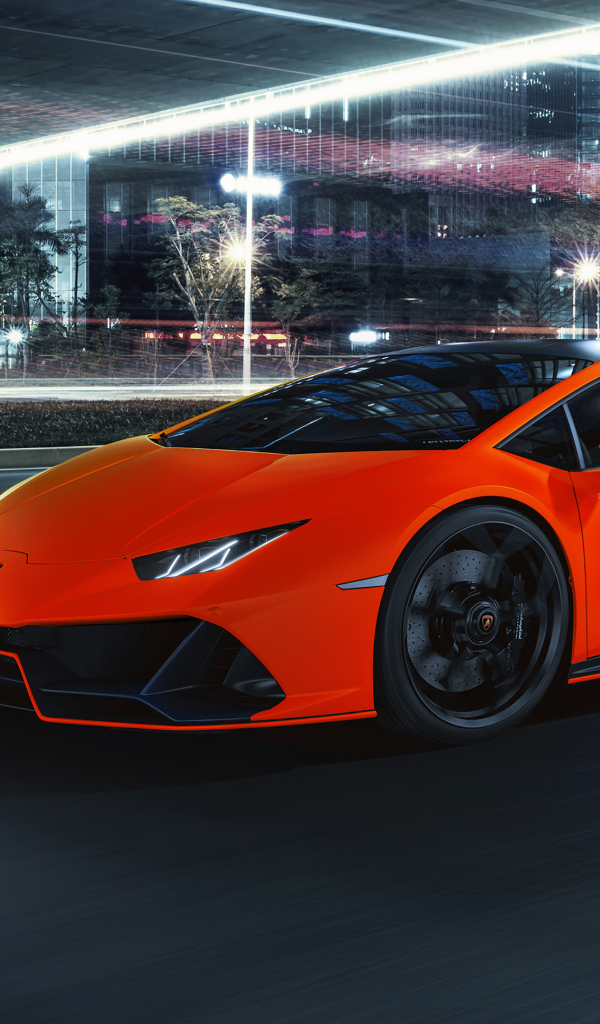 Оранжевый автомобиль Lamborghini Huracán EVO 2021 года на фоне города