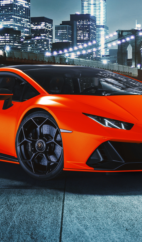 Оранжевый автомобиль Lamborghini Huracán EVO 2021 года на фоне небоскребов
