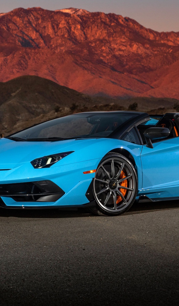 Голубой спортивный автомобиль Lamborghini Aventador SVJ Roadster, 2020 года на фоне гор