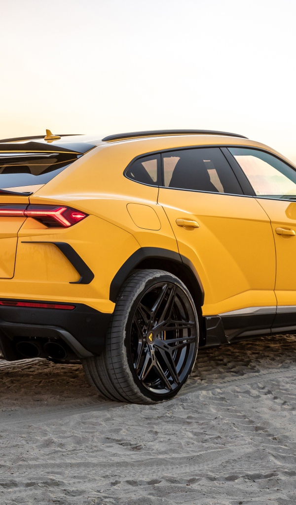 Желтый автомобиль  Lamborghini Urus на песке у моря