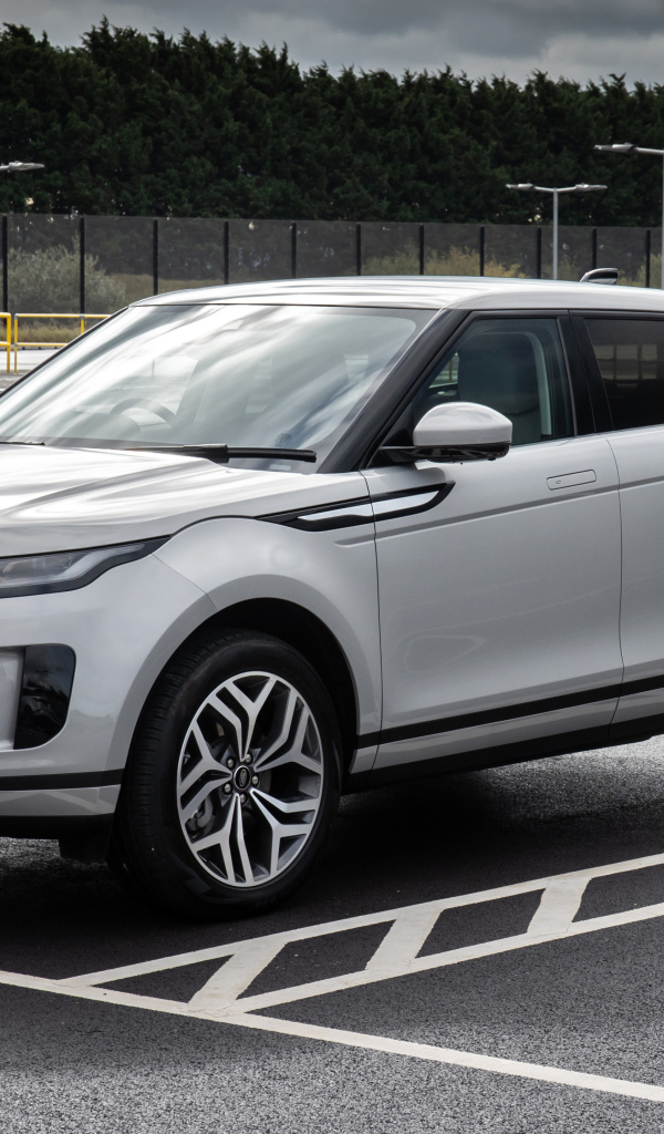 Серебристый автомобиль Range Rover Evoque P300e S 2020 года на заправке