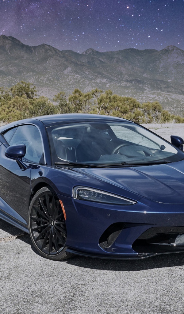 Черный автомобиль  McLaren GT, 2020 года под звездным небом