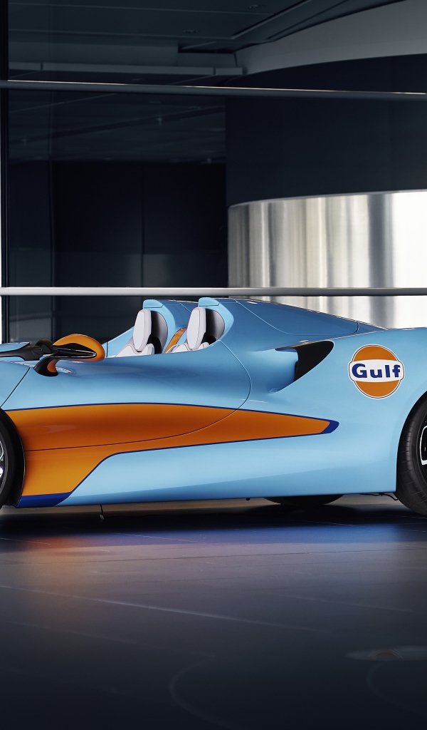 Спортивный автомобиль McLaren Elva Gulf Theme By MSO 2021 года у стеклянной стены 